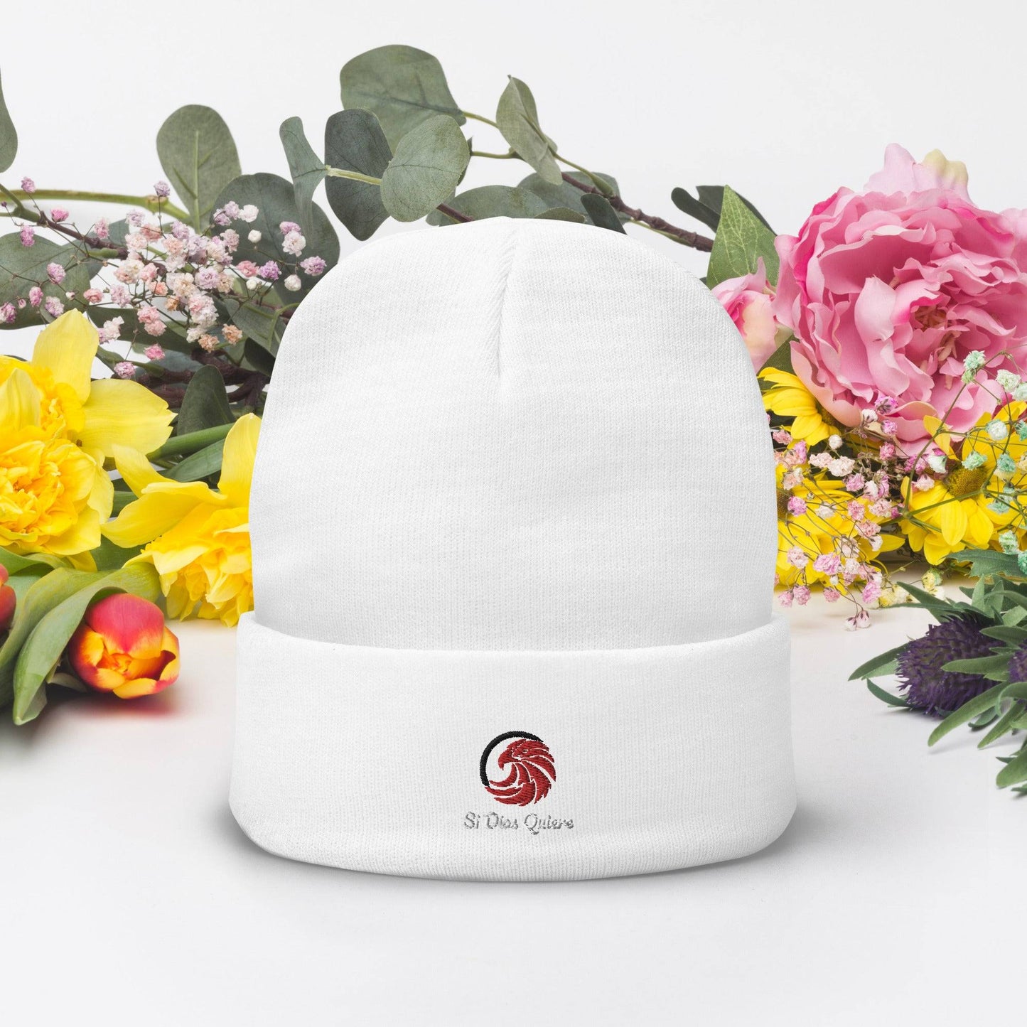 White beanie on table with flowers
